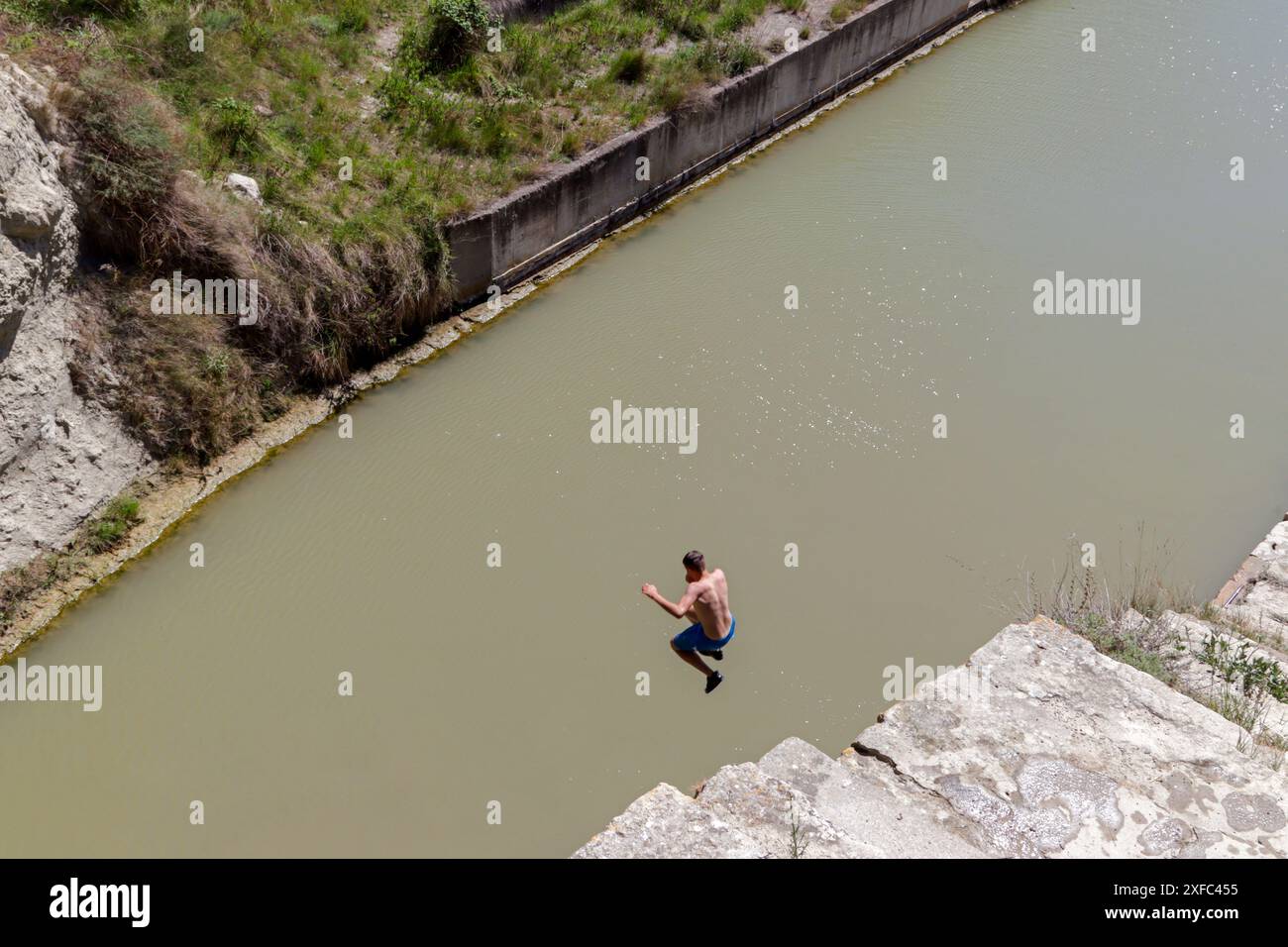 Jeune homme baignant par temps chaud à la sortie du tunnel de Malpas, creusé sous la colline de l'Enserune. Nissan-lez-Enserune, Occitanie, France Banque D'Images