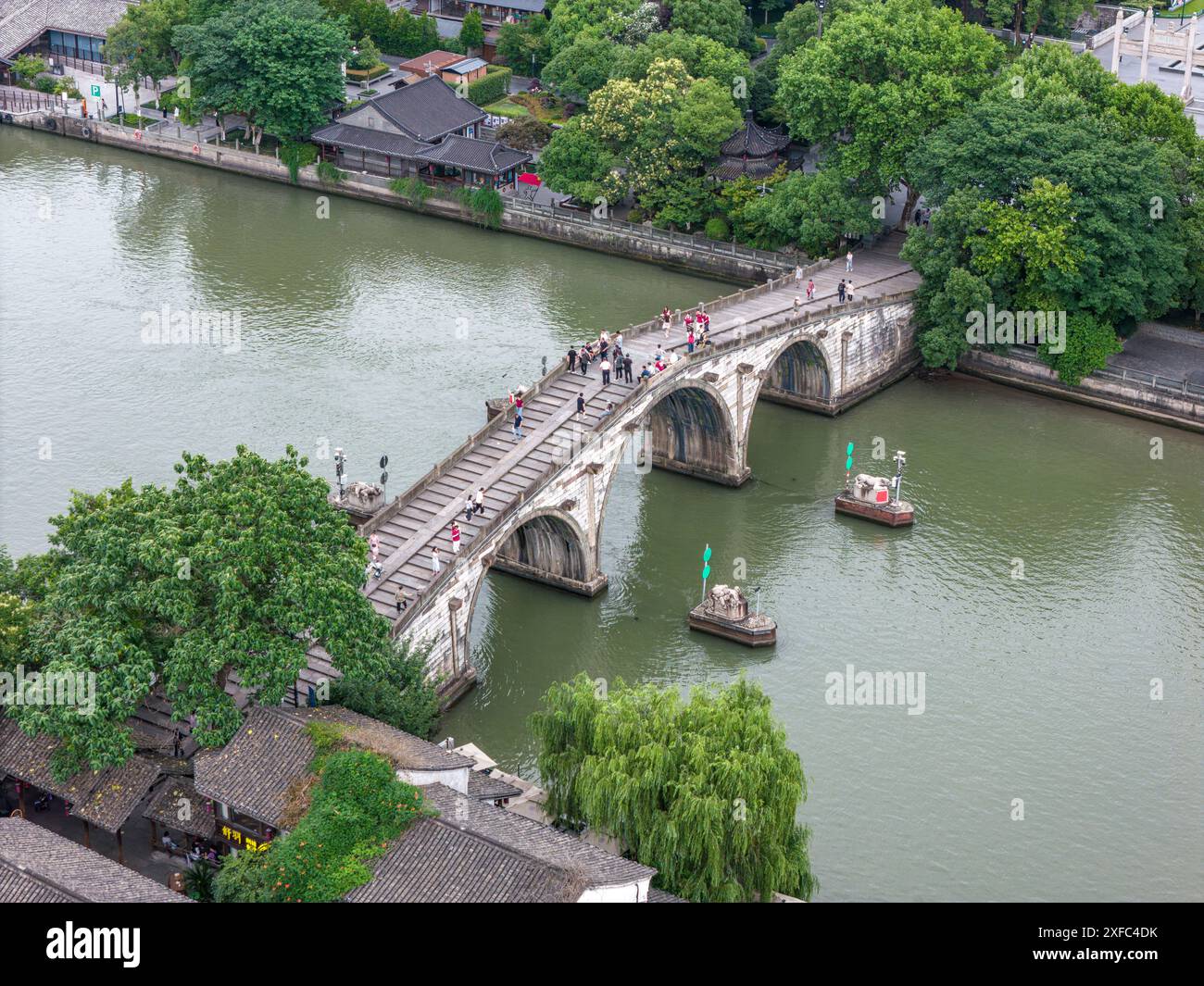 Une photo montre le pont Gongchen, le plus haut et le plus long pont en arc de pierre sur le Grand canal Beijing-Hangzhou, un bâtiment emblématique à l'extrémité sud du canal et site du patrimoine culturel mondial du Grand canal, à Hangzhou, Chine, le 18 juin 2024. Avec une longueur de 98 mètres et une hauteur de 16 mètres, le pont de Gongchen est large de 5,9 mètres au milieu du plancher du pont et large de 12,2 mètres à la fin du pont. C'est le pont en arc de pierre le plus haut et le plus long parmi les ponts anciens de Hangzhou et un bâtiment emblématique à l'extrémité sud du Grand canal. (Photo de Costfoto/ Banque D'Images