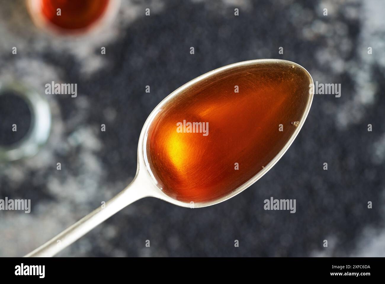 Cumin noir ou huile de graines de Nigella sativa sur une cuillère en métal, vue de dessus. Supplément anti-inflammatoire et antioxydant sain. Banque D'Images
