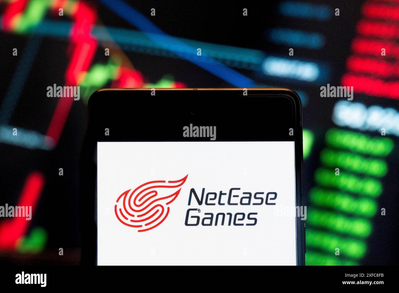 Dans cette illustration photo, la technologie Internet chinoise et les services en ligne, NetEase Games (NASDAQ : NTES), logo vu affiché sur un smartphone avec un graphique de l'indice boursier économique en arrière-plan. Banque D'Images