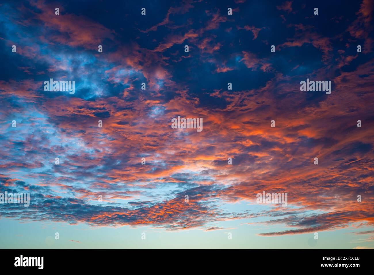 Ciel nocturne ardent en détail. Belles couleurs rouge, violet et orange des nuages au coucher du soleil. Banque D'Images