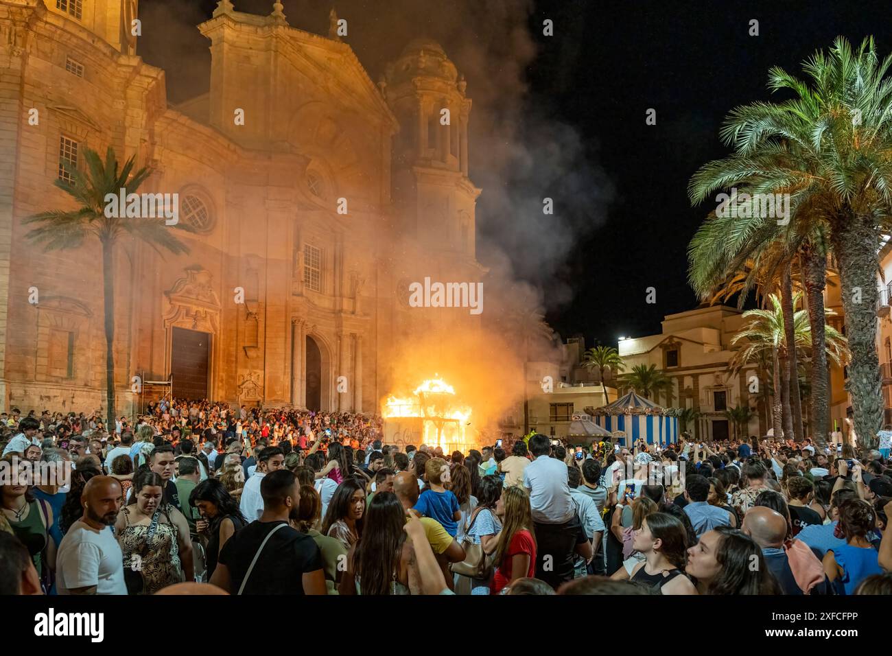 Les gens regardant un feu de joie pour célébrer le solstice d'été devant la cathédrale dans la nuit de San Juan (23 juin), Cadix, Andalousie, Espagne Banque D'Images