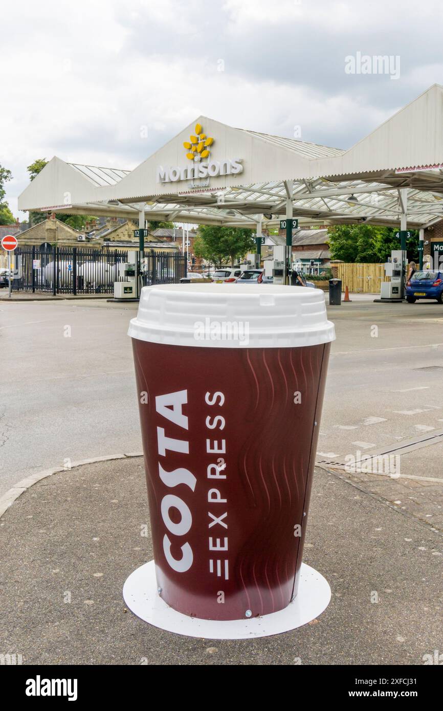 Un grand panneau publicitaire Costa Coffee devant une station-service Morrisons. Banque D'Images