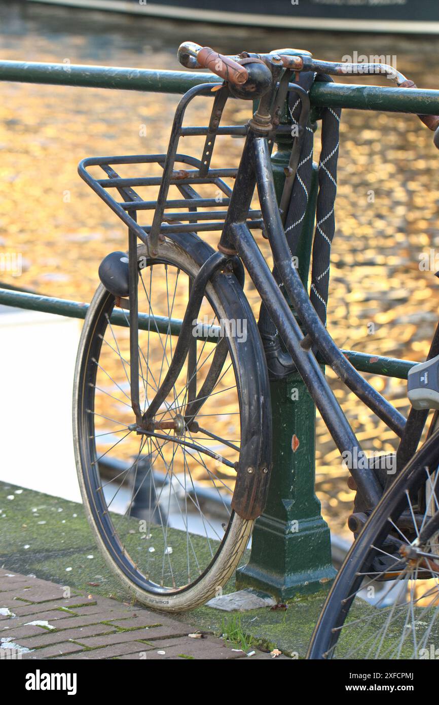 Vélos, vélos et vélos garés sur la route et contre le mur sur le pont sur le canal ensoleillé d'Amstel, Amsterdam ville pays-Bas. Banque D'Images