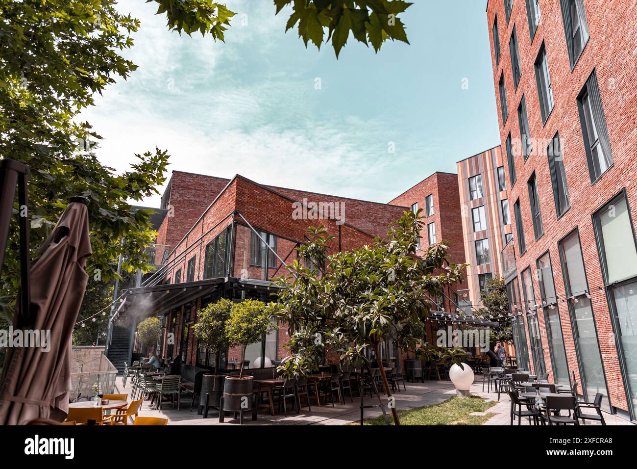 Tbilissi, Géorgie - 16 JUIN 2024 : complexe d'hôtels, cafés et restaurants sur la place Saarbrucken, accueillant l'Hôtel Moxy, Rigi Restaurant etc. Banque D'Images Tbilissi, Géorgie - 16 JUIN 2024 : complexe d'hôtels, cafés et restaurants sur la place Saarbrucken, accueillant l'Hôtel Moxy, Rigi Restaurant etc. Banque D'Images