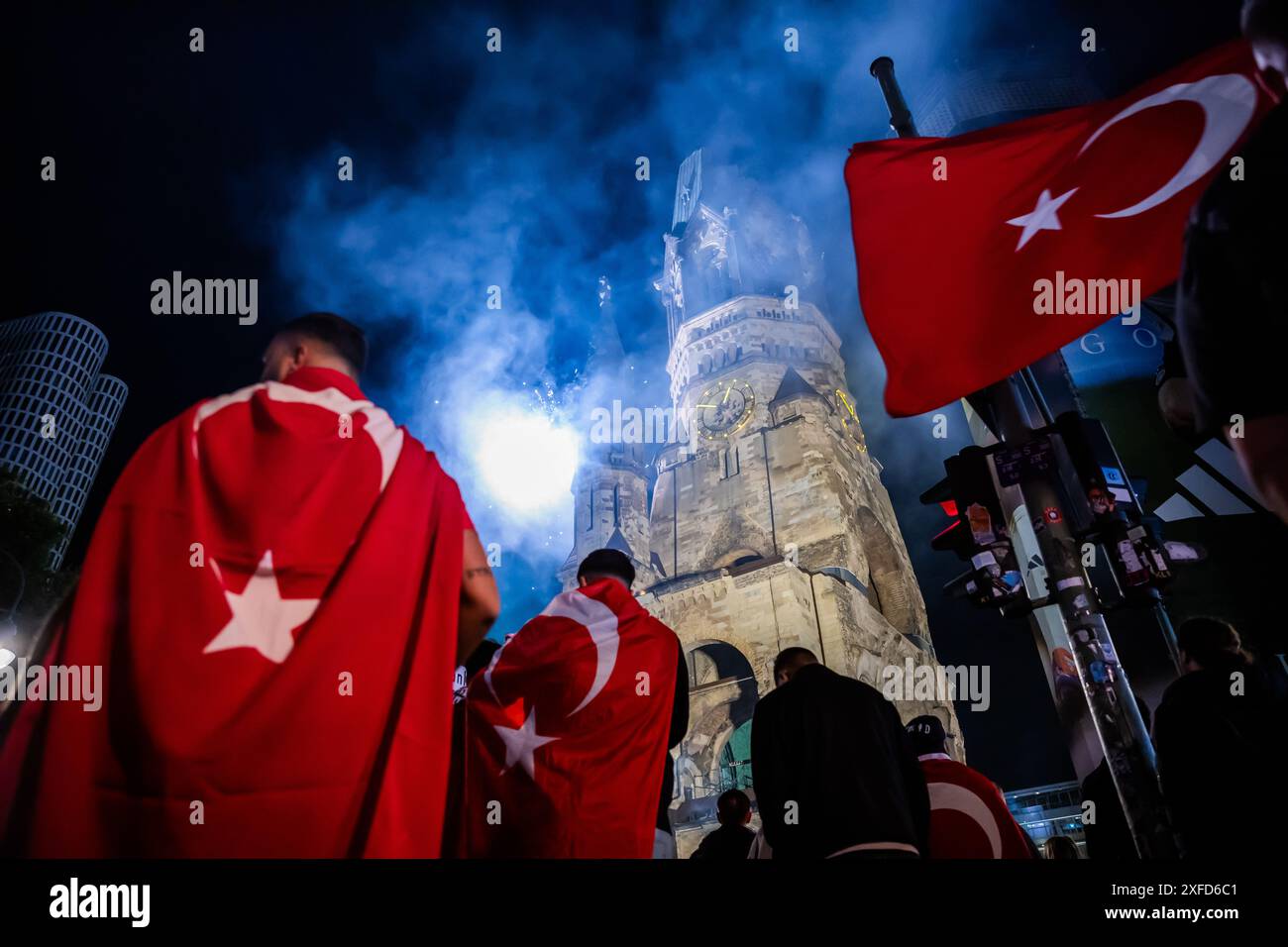 Berlin, Allemagne. 03 juillet 2024. Football : Championnat d'Europe, Autriche - Turquie, finale, manche 16. Les fans de Turquie célèbrent la victoire à Breitscheidplatz avec des pièces pyrotechniques devant l'église commémorative Kaiser Wilhelm. Crédit : Christoph Soeder/dpa/Alamy Live News Banque D'Images