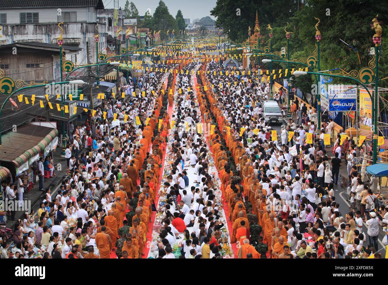 Nakhon si Thammarat, Thaïlande – 24 février 2013 : les bouddhistes s’unissent pour offrir l’aumône aux moines devant Wat Phra Mahathat Woramahawihan Banque D'Images