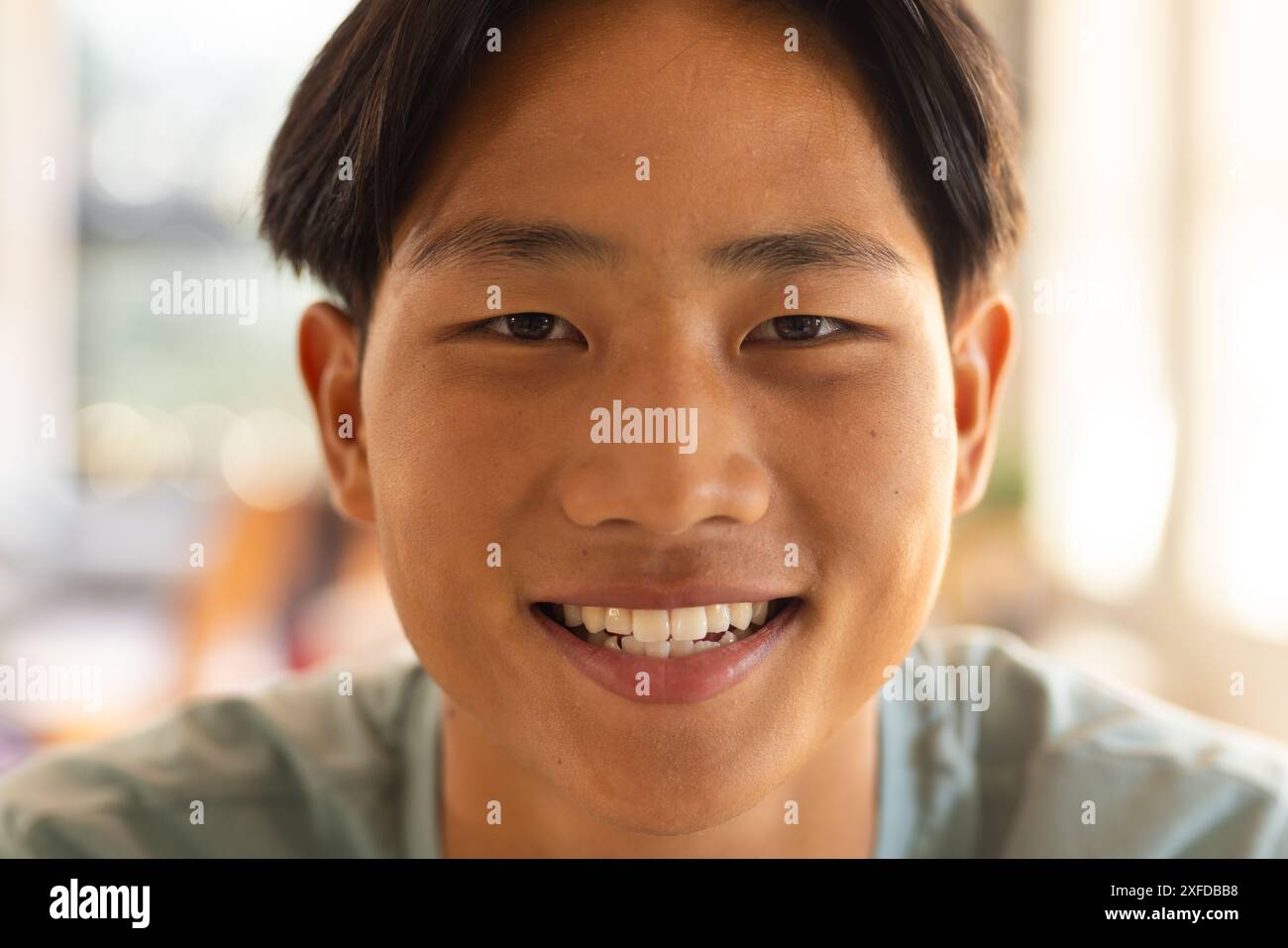 Adolescent souriant au lycée, regardant la caméra avec une expression lumineuse Banque D'Images