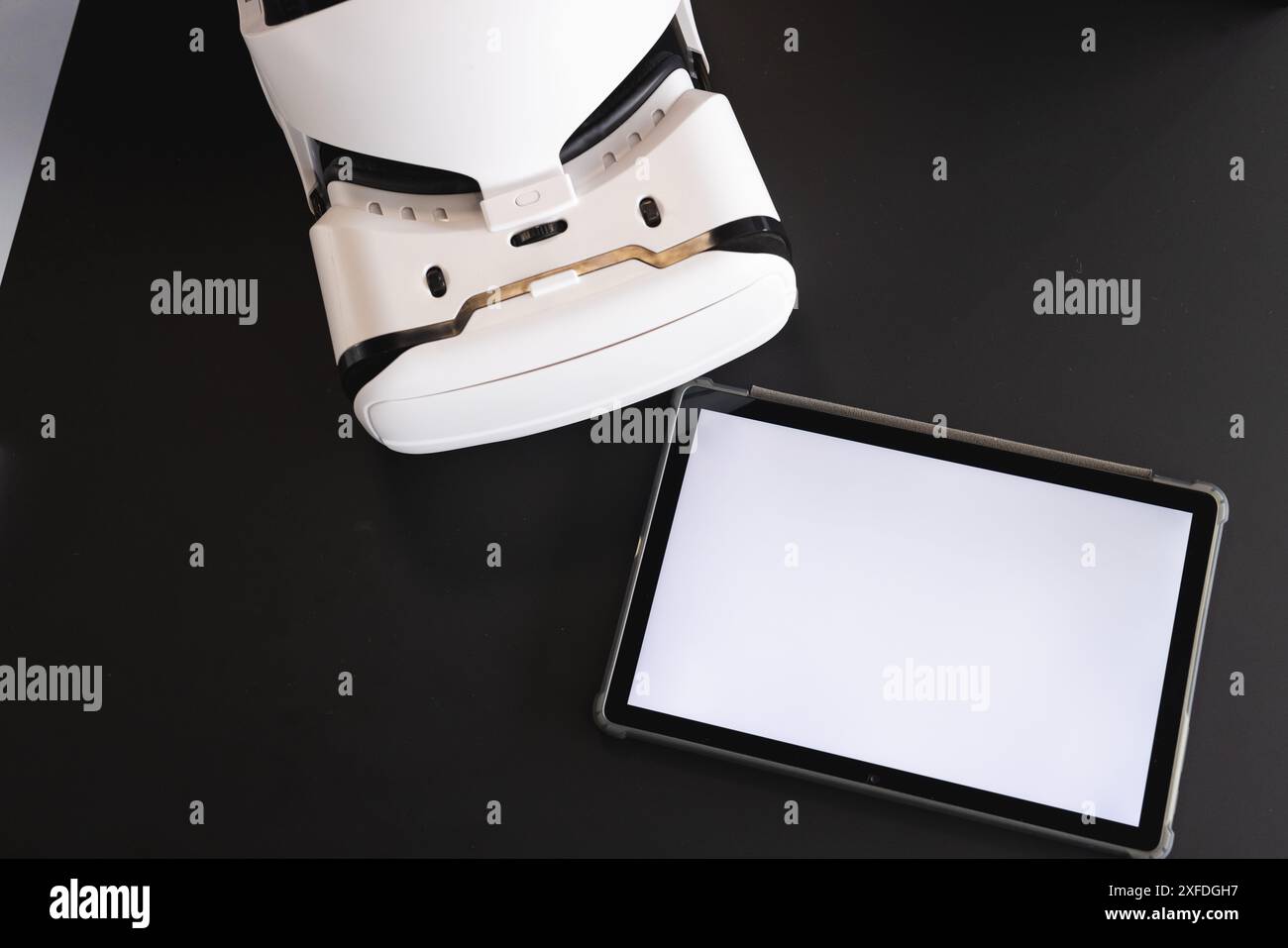 Casque de réalité virtuelle et tablette sur bureau noir pour la présentation d'affaires, espace de copie Banque D'Images