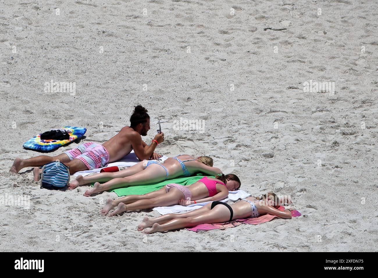 Les gens en train de bronzer sur une plage de sable Banque D'Images