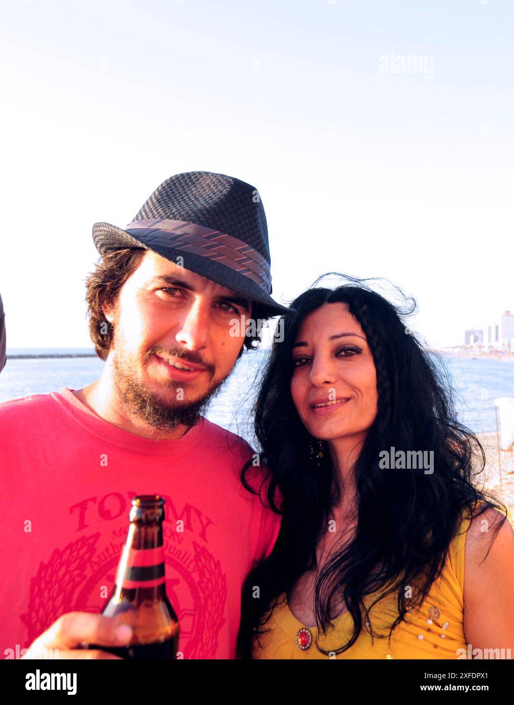 Un couple dégustant leurs bières au bord de la plage à tel-Aviv, Israël. Banque D'Images