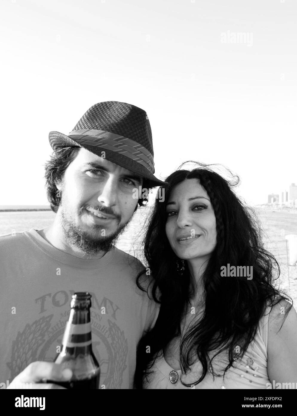 Un couple dégustant leurs bières au bord de la plage à tel-Aviv, Israël. Banque D'Images