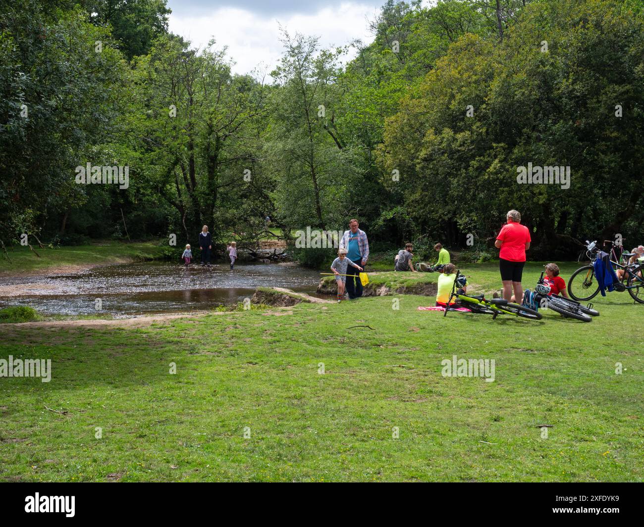 Cyclistes et gens à côté de l'Avon Water Stream, par Wootton Copse, New Forest National Park, Hampshire, Angleterre, Royaume-Uni, juillet 2020 Banque D'Images