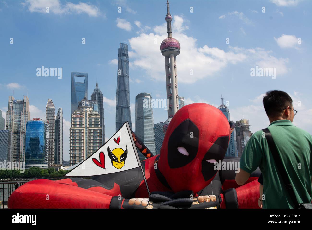 Shanghai, Chine. 03 juillet 2024. Les gens prennent des photos avec une grande figure d'une montgolfière de Wolverine et Deadpool, qui se repose à North Bund à Shanghai, en Chine, le 3 juillet. Le nouveau film 2024 commence sa tournée de presse à travers le monde. (Photo de Ying Tang/NurPhoto) crédit : NurPhoto SRL/Alamy Live News Banque D'Images