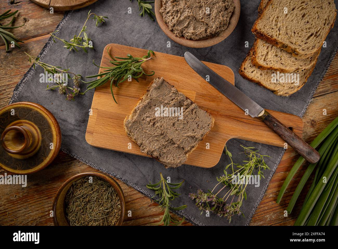 Vue de dessus de délicieux pâté de foie maison avec du pain et des herbes sur la table rustique Banque D'Images