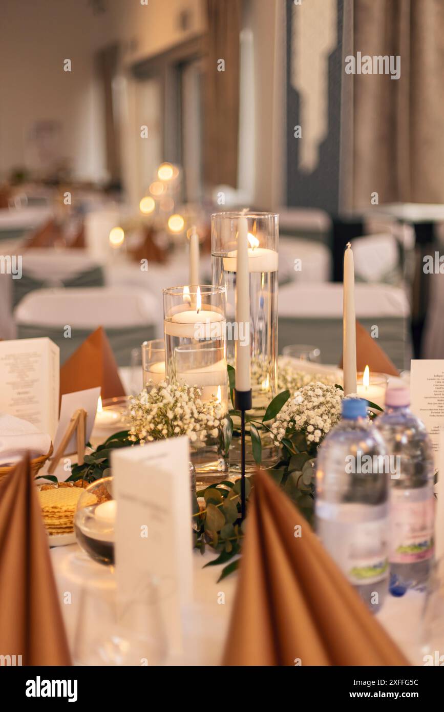 Le cadre intime et chaleureux de la table éclairée aux chandelles crée une atmosphère romantique lors d'une réception de mariage Banque D'Images