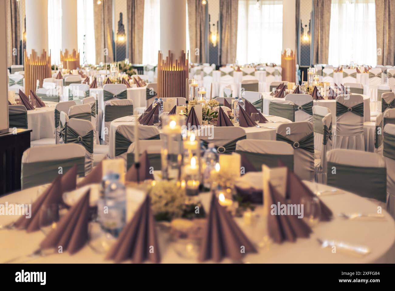 Réception sophistiquée avec tables décorées et éclairage moderne dans une salle de banquet Banque D'Images