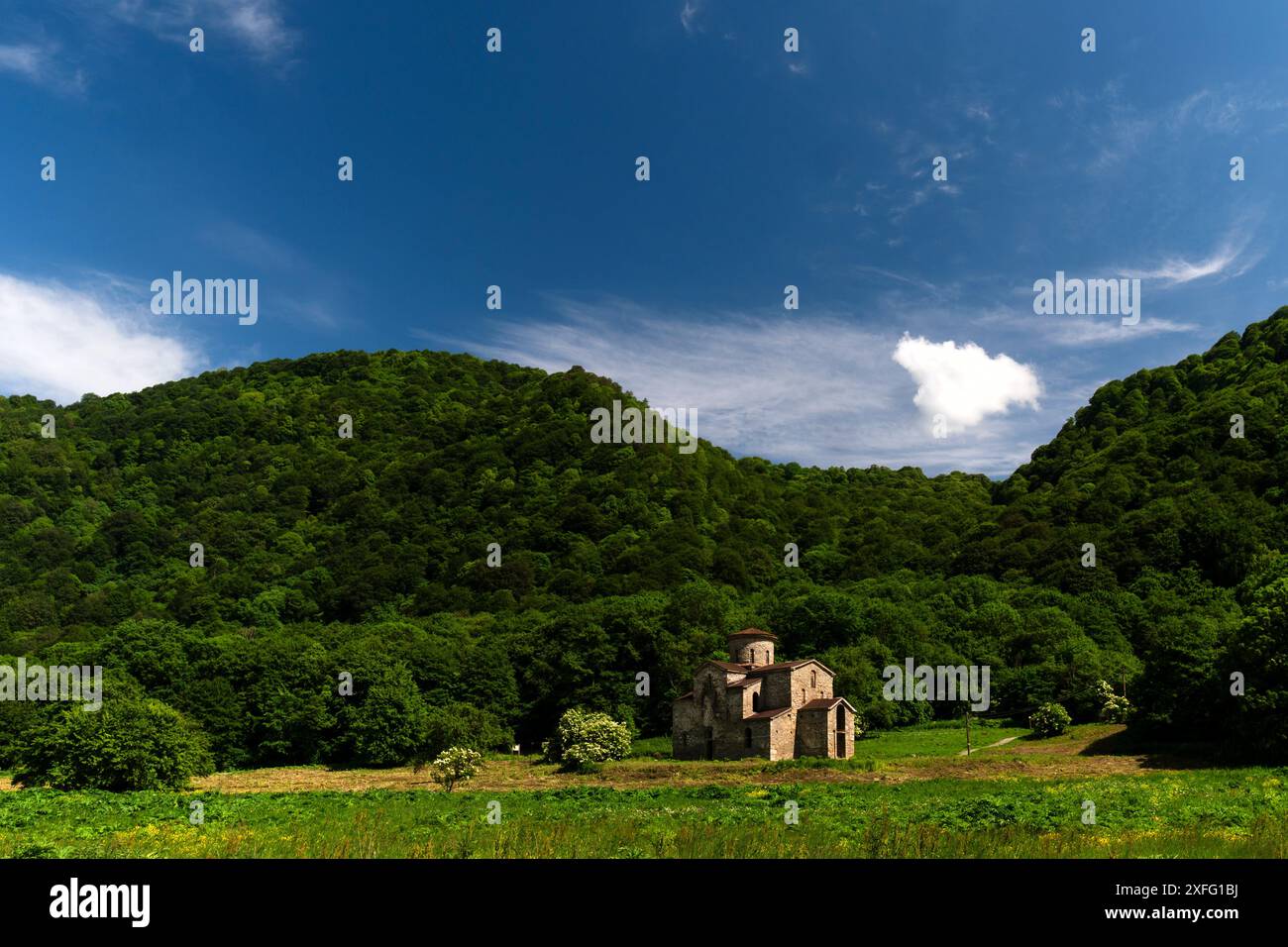 Ancienne église en pierre dans la vallée verdoyante avec les collines environnantes. L'église centrale Zelenchuchsky est un churchin alanien de la colonie Karachay-Che inférieure-Arkhyz Banque D'Images