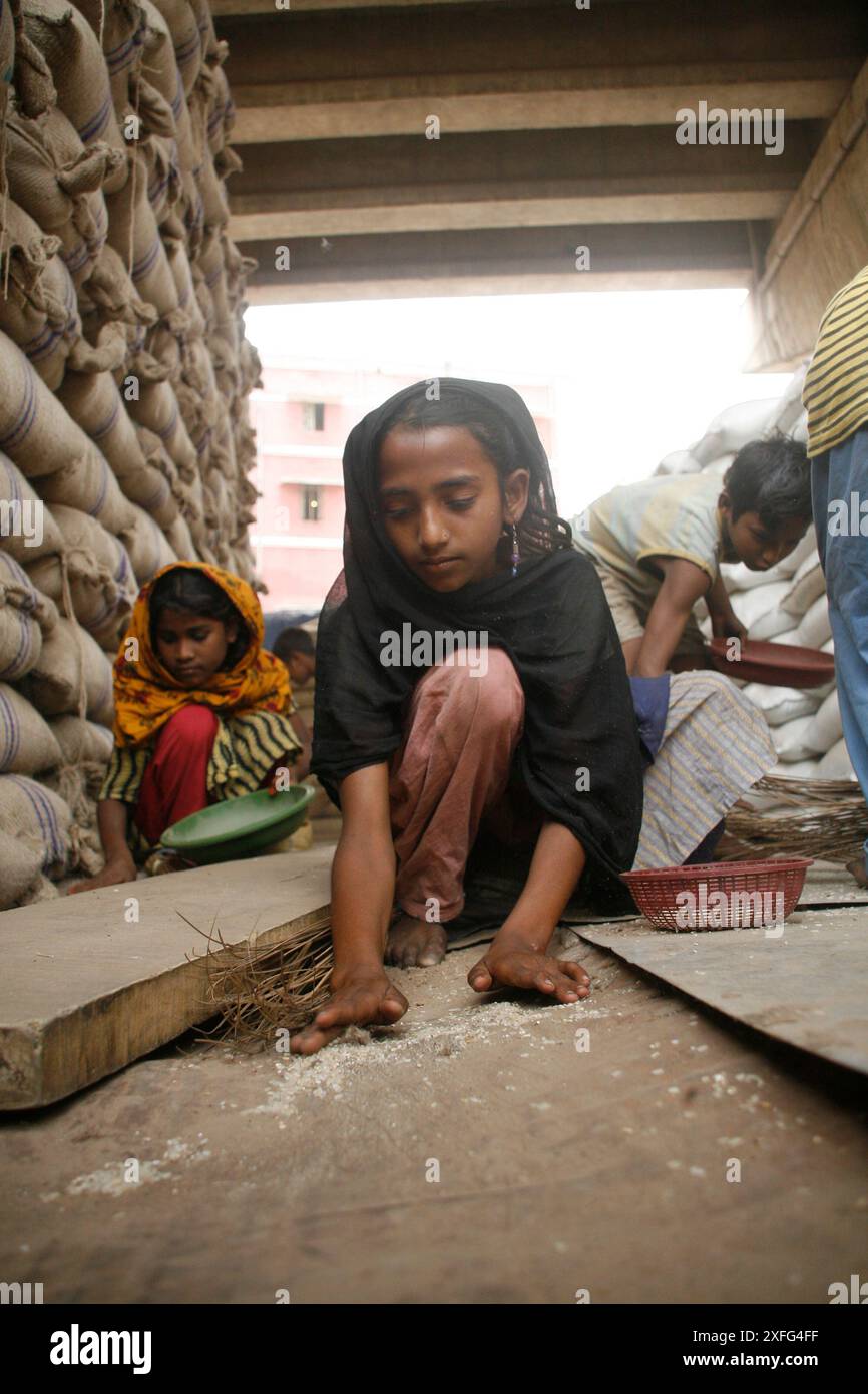 Les enfants ramassent les restes de riz au marché de gros de Badamtoli dimanche, incapables de se payer les produits essentiels à cause de la flambée des prix. 06 avril 2008 Banque D'Images