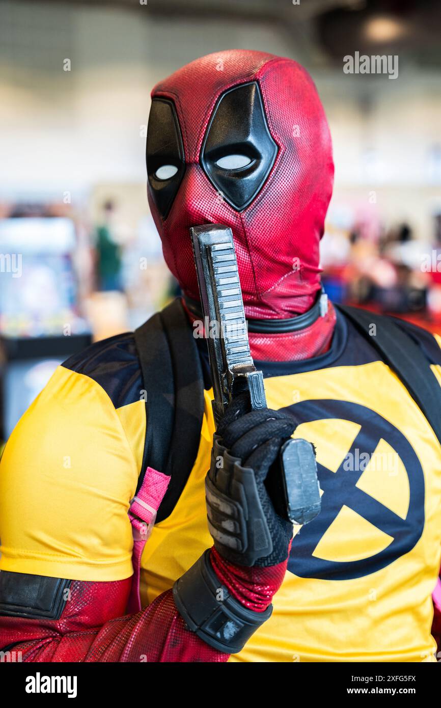 HARROGATE, ROYAUME-UNI 22 JUIN 2024. Gros plan portrait d'un cosplayer masculin habillé en Deadpool et posant avec un pistolet et des vêtements Wolverine Banque D'Images