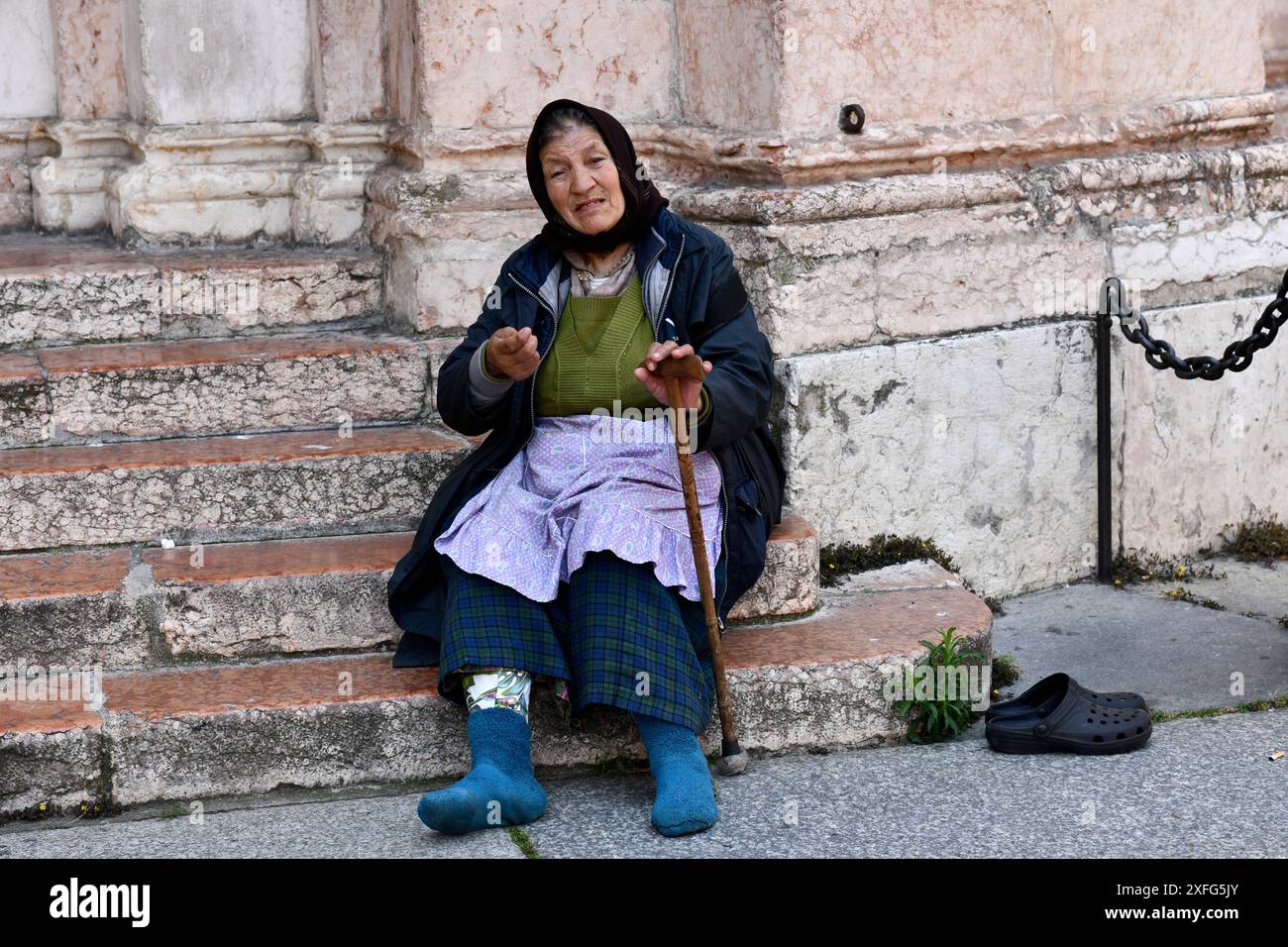 Vieille dame mendiant devant la cathédrale de Parme, Parme, Emilie-Romagne, Italie Banque D'Images