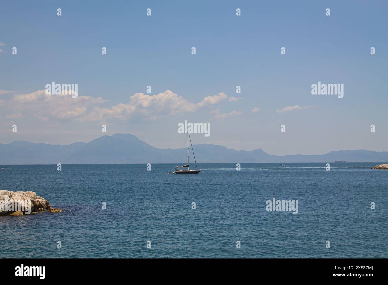 Yacht dans la mer sur le fond des montagnes. Bateau flottant dans le golfe de Naples, Italie du sud. Vacances italiennes, lieux touristiques Banque D'Images