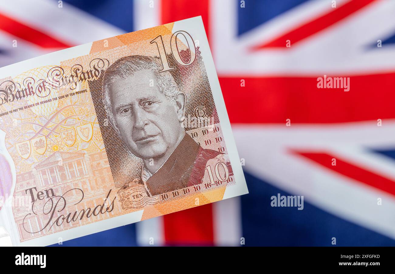 Nouvelle monnaie britannique mettant en vedette le roi Charles III, émise pour la première fois en juin 2024 par la Banque d'Angleterre au Royaume-Uni. Le drapeau britannique est en arrière-plan Banque D'Images