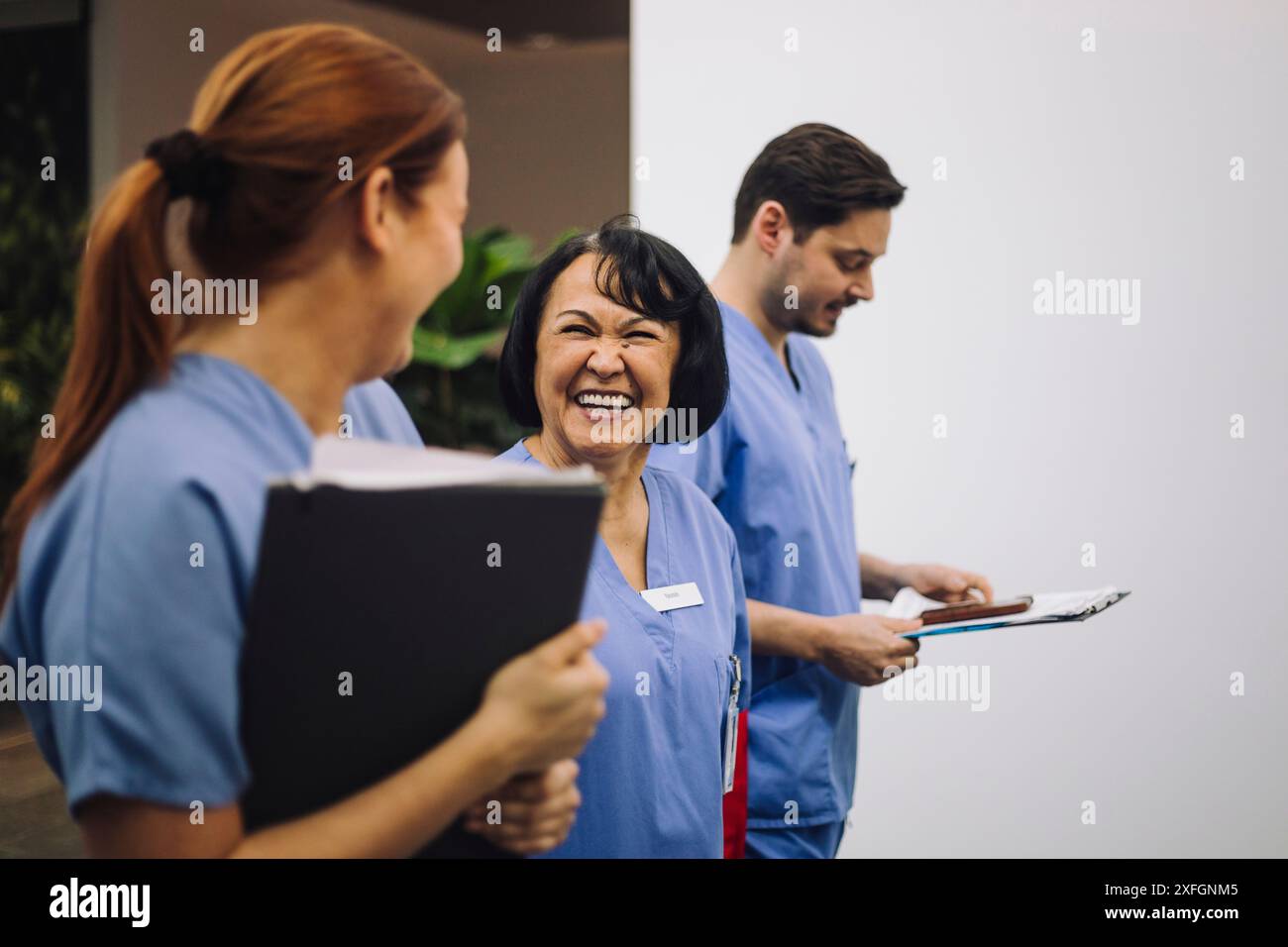 Médecin senior parlant avec une collègue dans le couloir de l'hôpital Banque D'Images