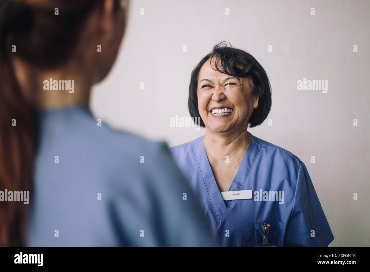Heureuse médecin senior parlant avec une collègue Banque D'Images