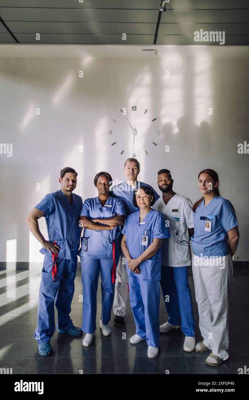Portrait de professionnels de santé masculins et féminins debout ensemble devant un mur à l'hôpital Banque D'Images