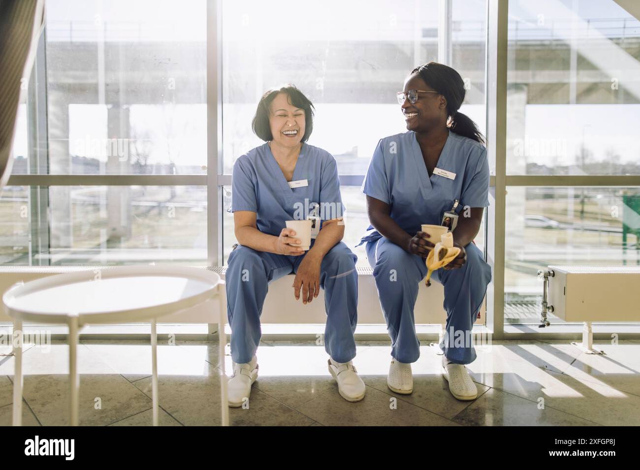 Femmes professionnelles heureuses appréciant pendant la pause café à l'hôpital Banque D'Images