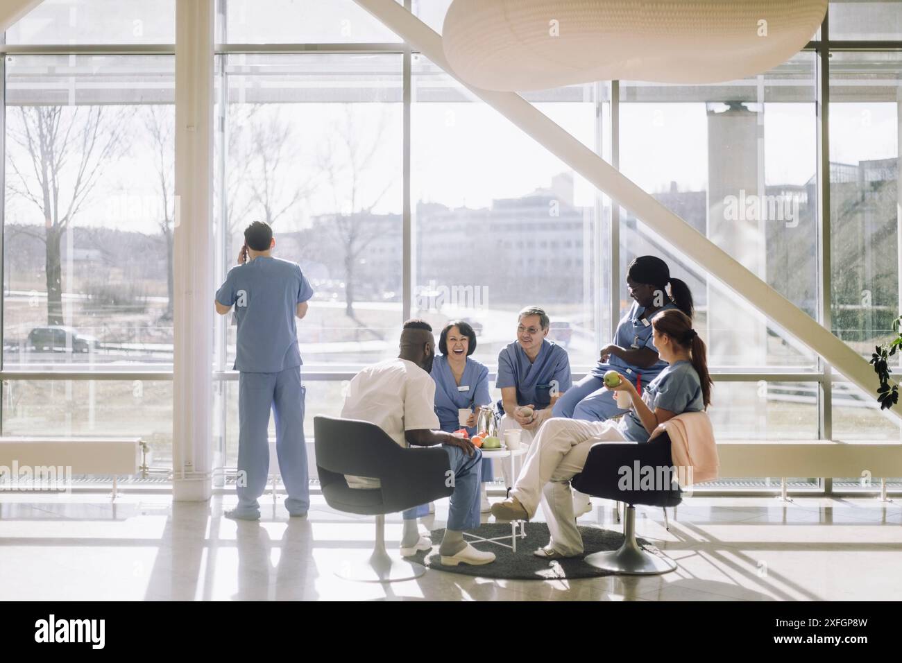 Équipe de professionnels médicaux masculins et féminins s'amusant pendant la pause café à la cafétéria de l'hôpital Banque D'Images