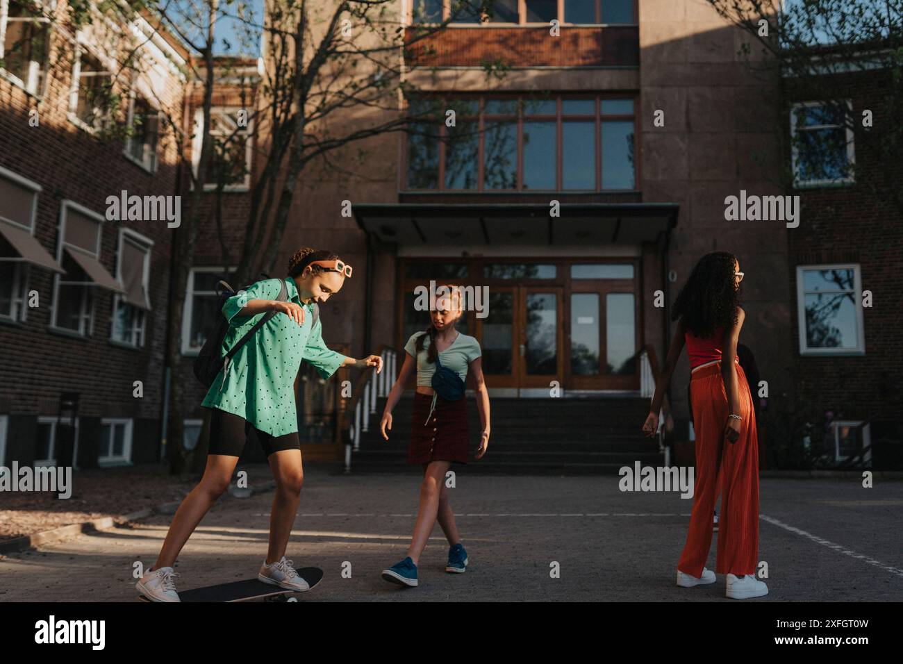 Les filles passent du temps libre tout en jouant à l'extérieur du campus Banque D'Images