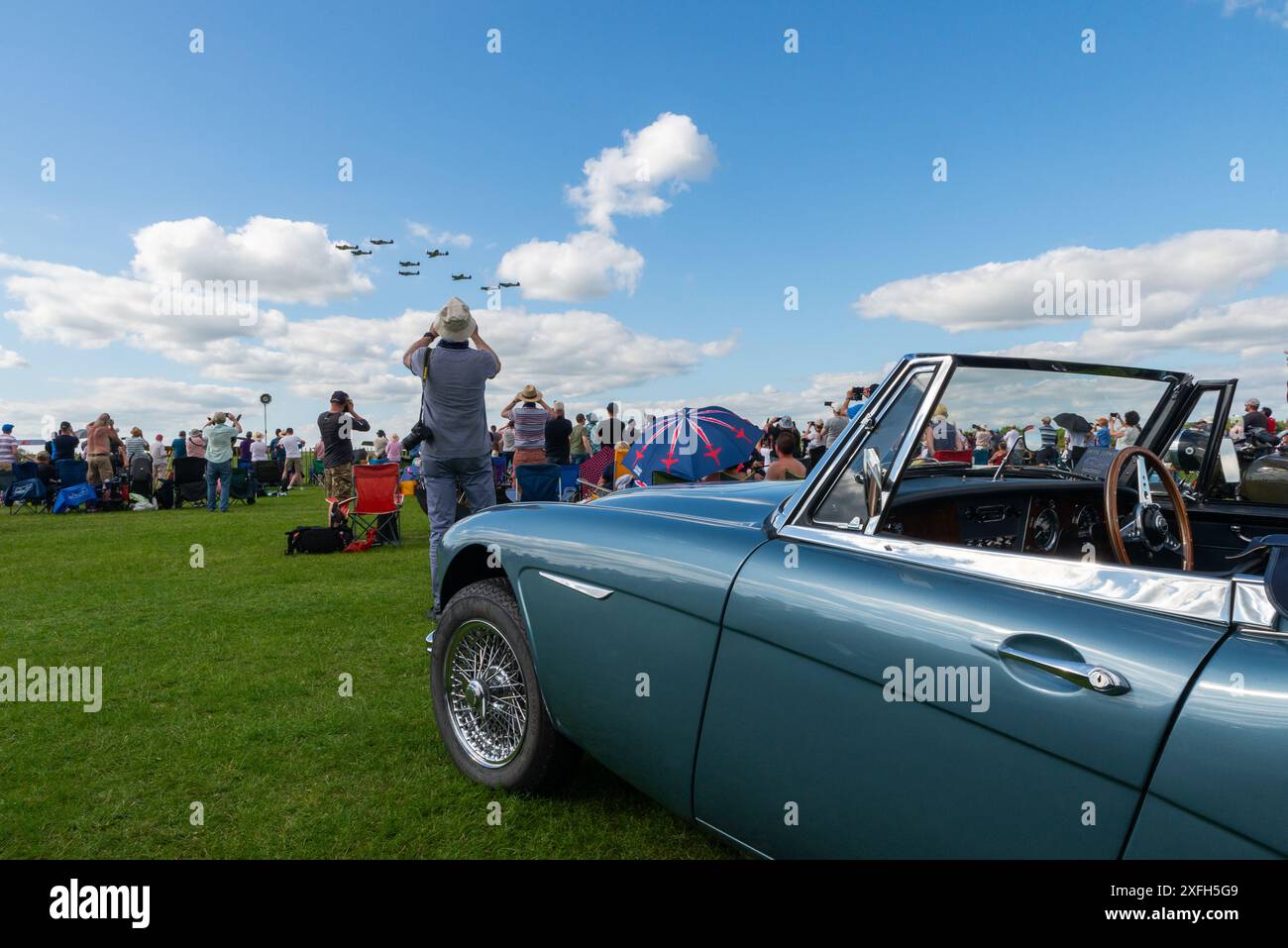 Foule de spectacles aériens regardant un flypast d'avions Spitfire de la seconde Guerre mondiale. Voitures de collection et amateurs au Sywell Airshow 2024 Banque D'Images