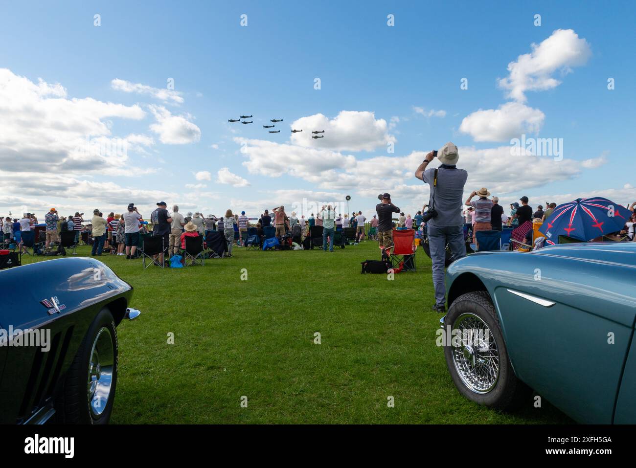 Foule de spectacles aériens regardant un flypast d'avions Spitfire de la seconde Guerre mondiale. Voitures de collection et amateurs au Sywell Airshow 2024 Banque D'Images