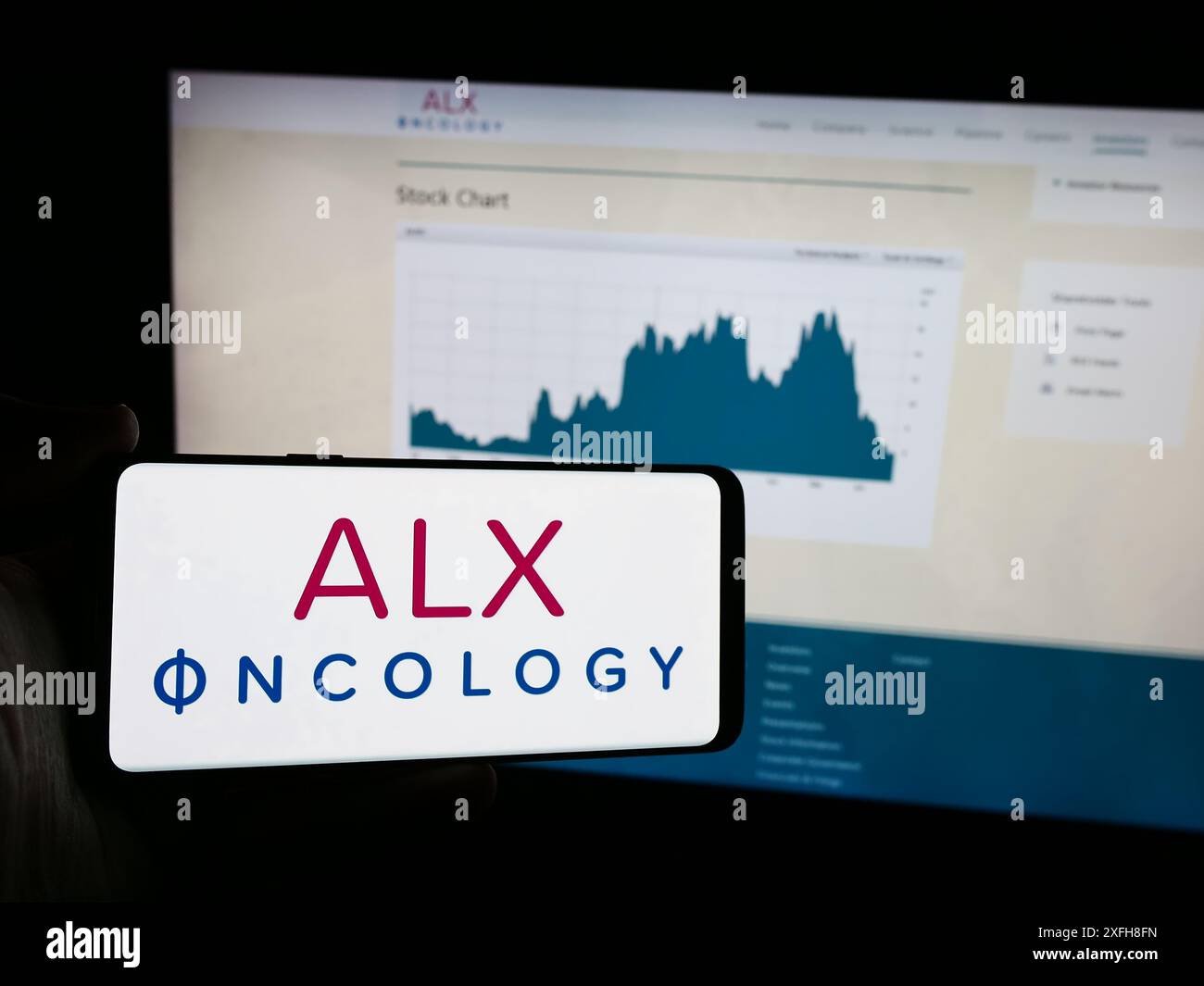 Personne tenant le téléphone portable avec le logo de la société américaine de thérapie du cancer ALX Oncology Inc devant la page Web de l'entreprise. Concentrez-vous sur l'affichage du téléphone. Banque D'Images