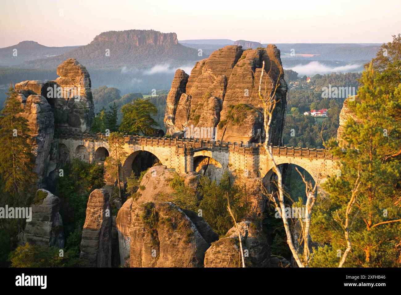 Lever du soleil sur les superbes formations rocheuses et l'ancien pont du parc national de la Suisse saxonne, mettant en valeur la beauté de la nature dans la lumière du matin Banque D'Images Lever du soleil sur les superbes formations rocheuses et l'ancien pont du parc national de la Suisse saxonne, mettant en valeur la beauté de la nature dans la lumière du matin Banque D'Images