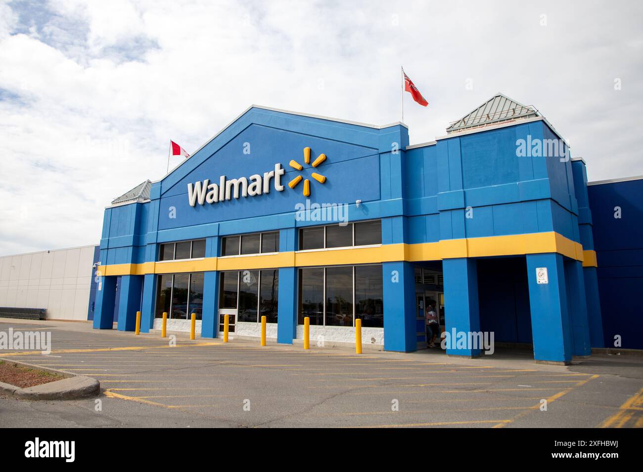 Kanata, Canada - 2 juin 2024 : immeuble de magasins de détail Walmart avec drapeaux canadiens et ontariens Banque D'Images