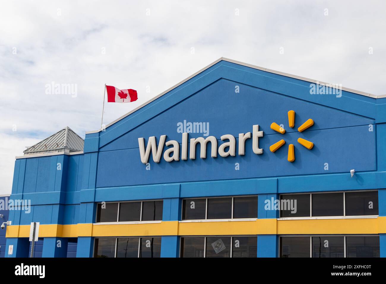 Kanata, Canada - 2 juin 2024 : immeuble de magasins de détail Walmart avec drapeau canadien Banque D'Images