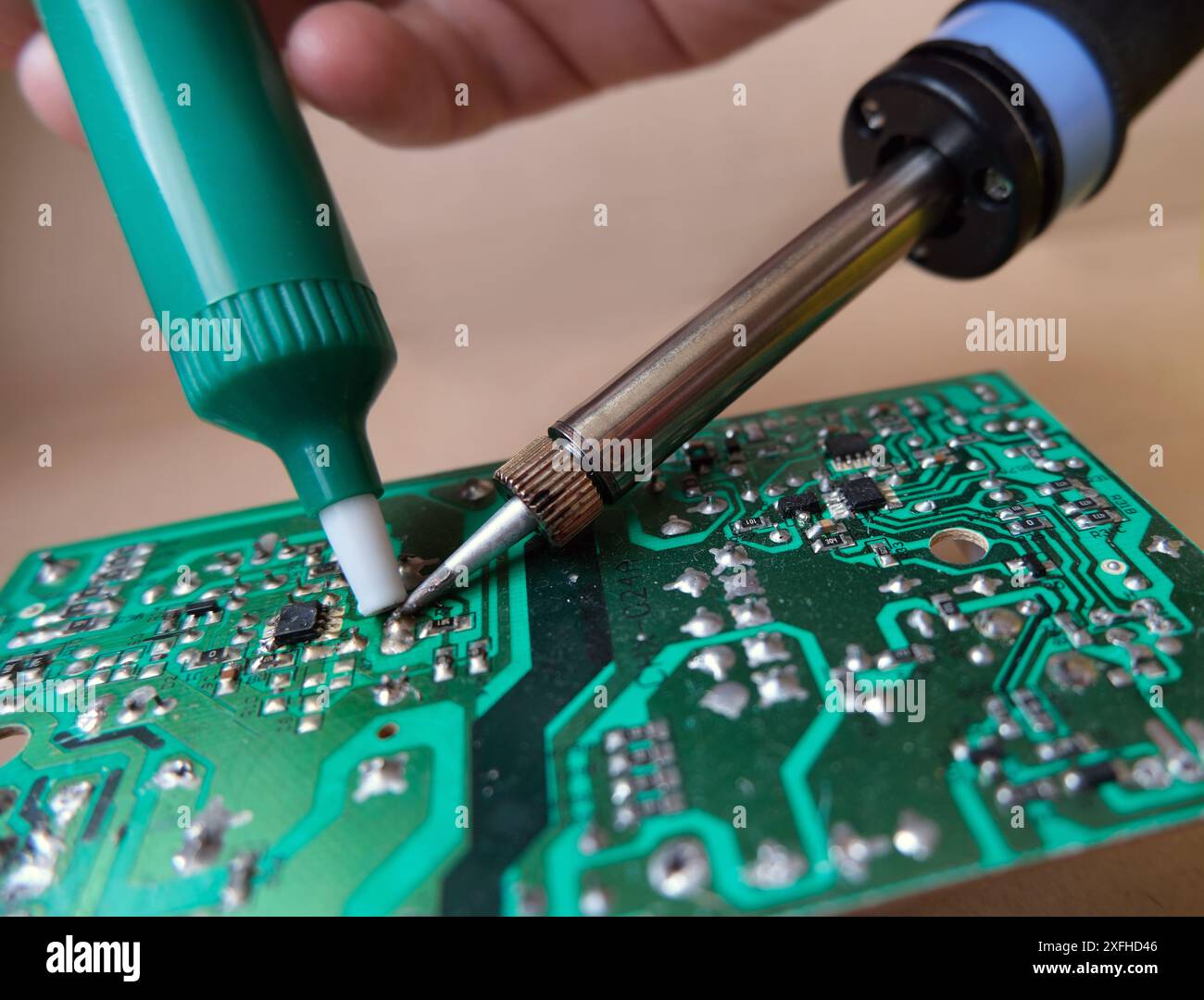 Équipement de réparation électronique pour technicien ou réparateur. Travail de dessoudage avec une pompe et un fer à souder. Banque D'Images