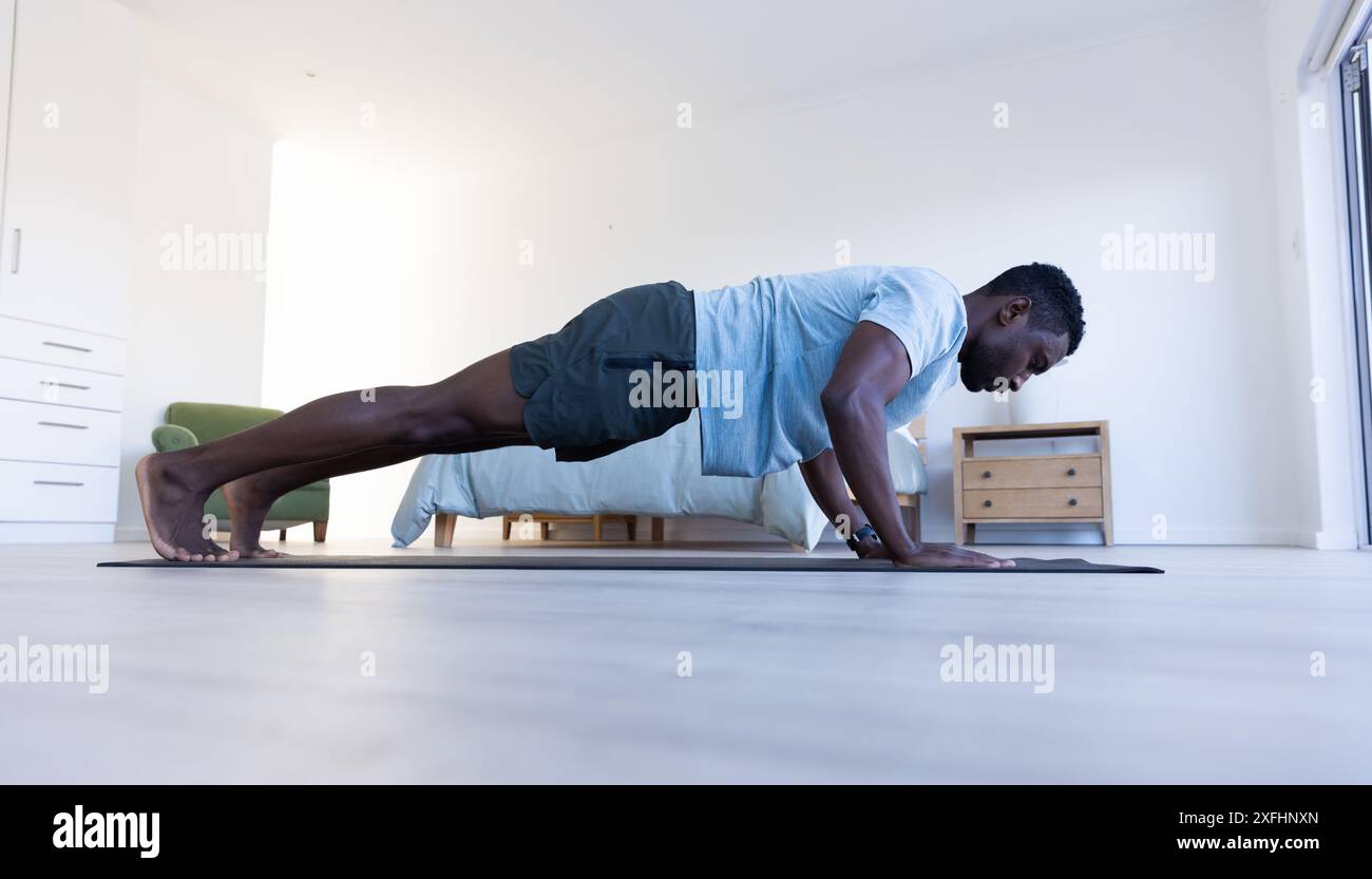 Faire des pompes sur tapis de yoga, homme exerçant dans la chambre à coucher pour l'entraînement à la maison Banque D'Images
