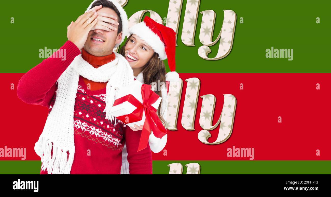 Image de texte joyeux sur des rayures rouges et vertes et couple heureux avec chapeaux de noël et cadeau Banque D'Images