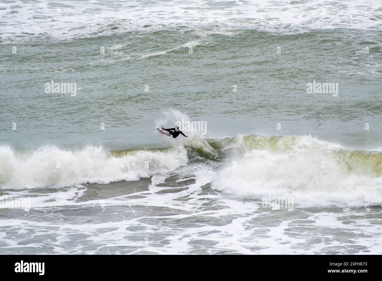 Surfeur à Muriwai Gannet Colony Beach - Nouvelle-Zélande Banque D'Images