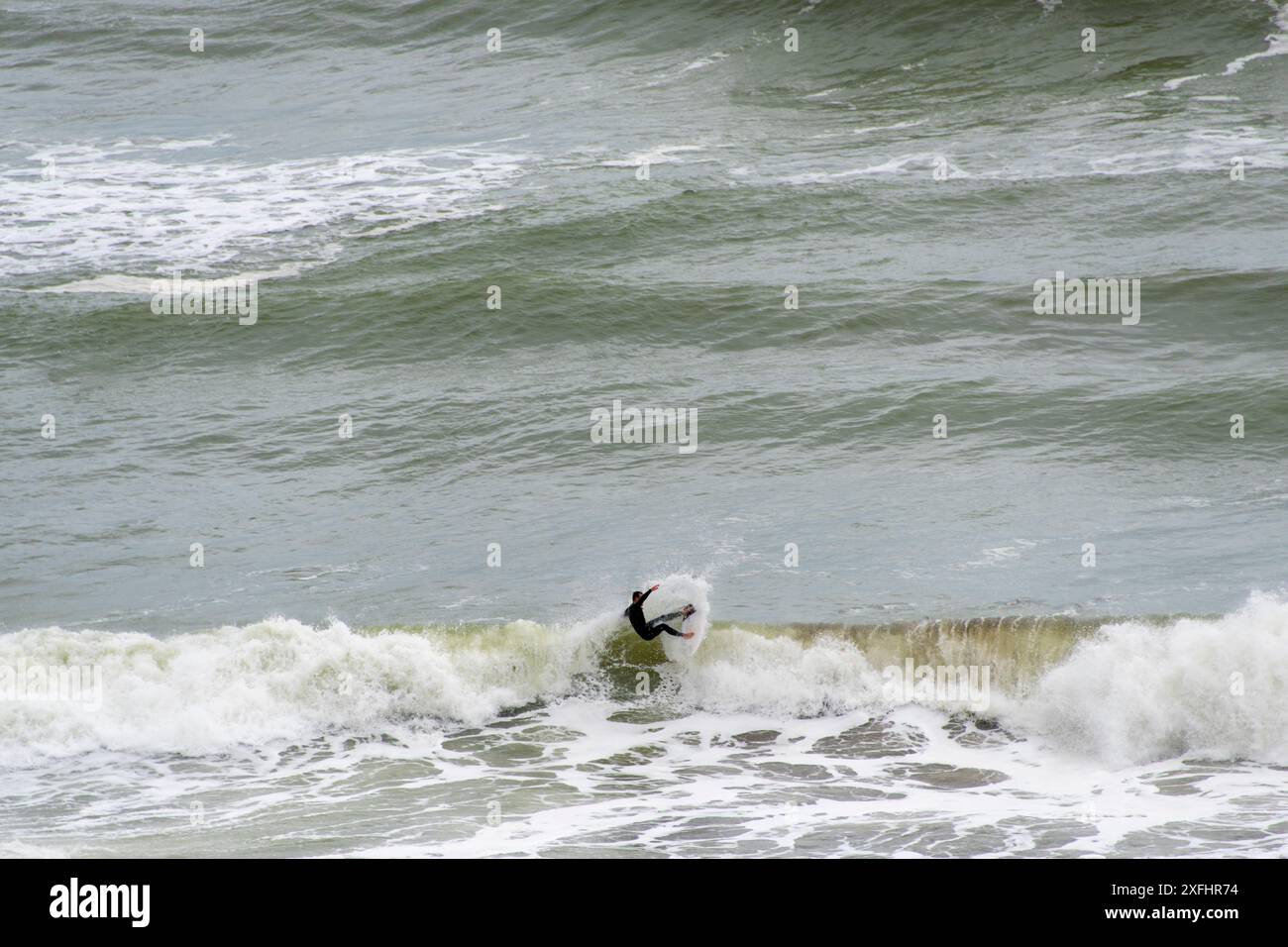 Surfeur à Muriwai Gannet Colony Beach - Nouvelle-Zélande Banque D'Images