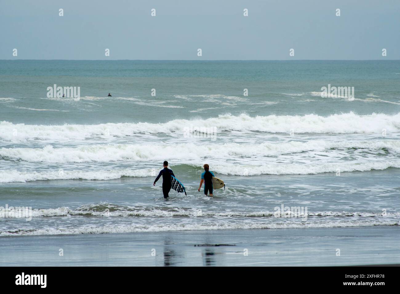Surfeur à Muriwai Gannet Colony Beach - Nouvelle-Zélande Banque D'Images