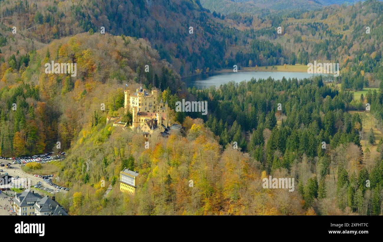 Une belle montagne avec un château au sommet et un lac en arrière-plan. Le château est entouré d'arbres et le lac est calme et paisible Banque D'Images