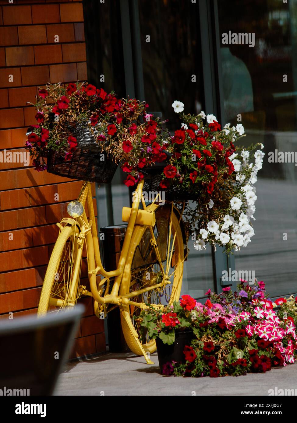 Vélo jaune avec paniers de fleurs Banque D'Images Vélo jaune avec paniers de fleurs Banque D'Images