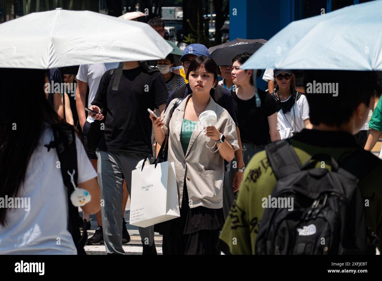 Tokyo, Japon. 4 juillet 2024. Des gens marchent dans une rue à Tokyo, Japon, 4 juillet 2024. Le Japon a connu une forte chaleur estivale dans de nombreuses régions, y compris Tokyo avec des températures dépassant les 35 degrés Celsius, ce qui a déclenché la première alerte de coup de chaleur de l'année pour la région de Tokyo. Crédit : Zhang Xiaoyu/Xinhua/Alamy Live News Banque D'Images