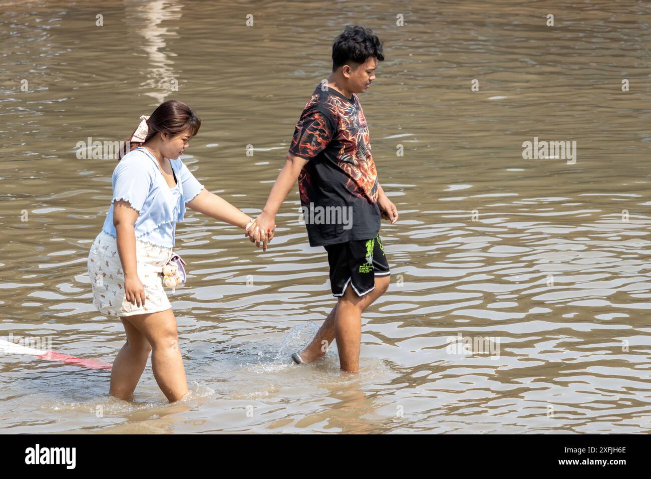 SAMUT PRAKAN, THAÏLANDE, février 02 2024, Un couple patente dans une rue inondée Banque D'Images