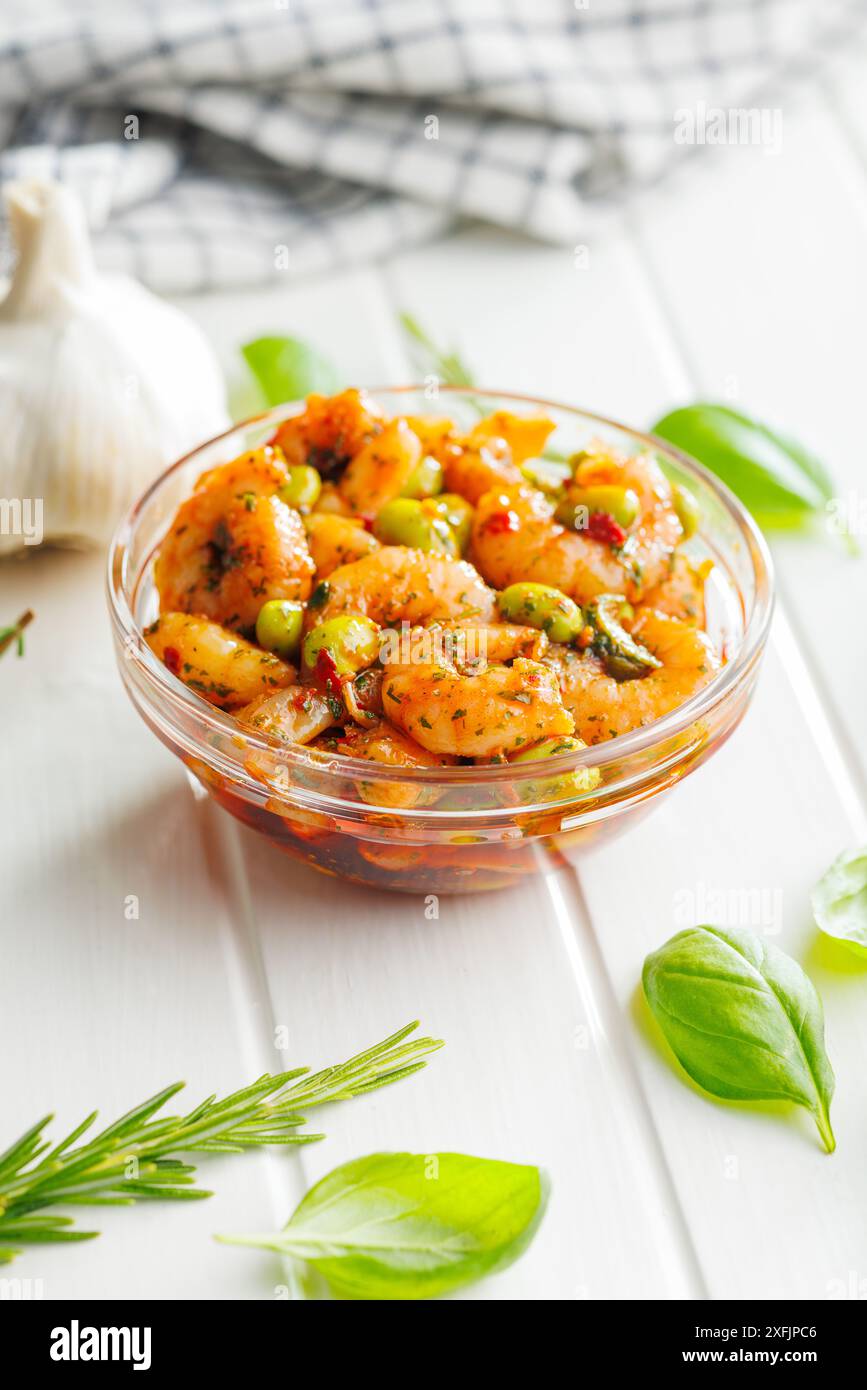 Salade fraîche avec crevettes et soja edamame dans un bol sur une table blanche. Banque D'Images